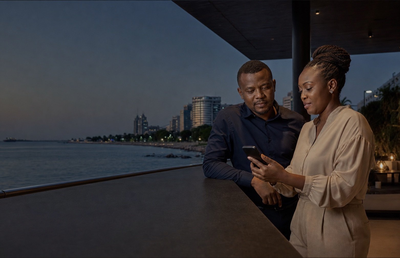 Watu wazima wawili wakitazama taarifa kwenye simu kando ya bahari Dar es Salaam wakati wa jioni